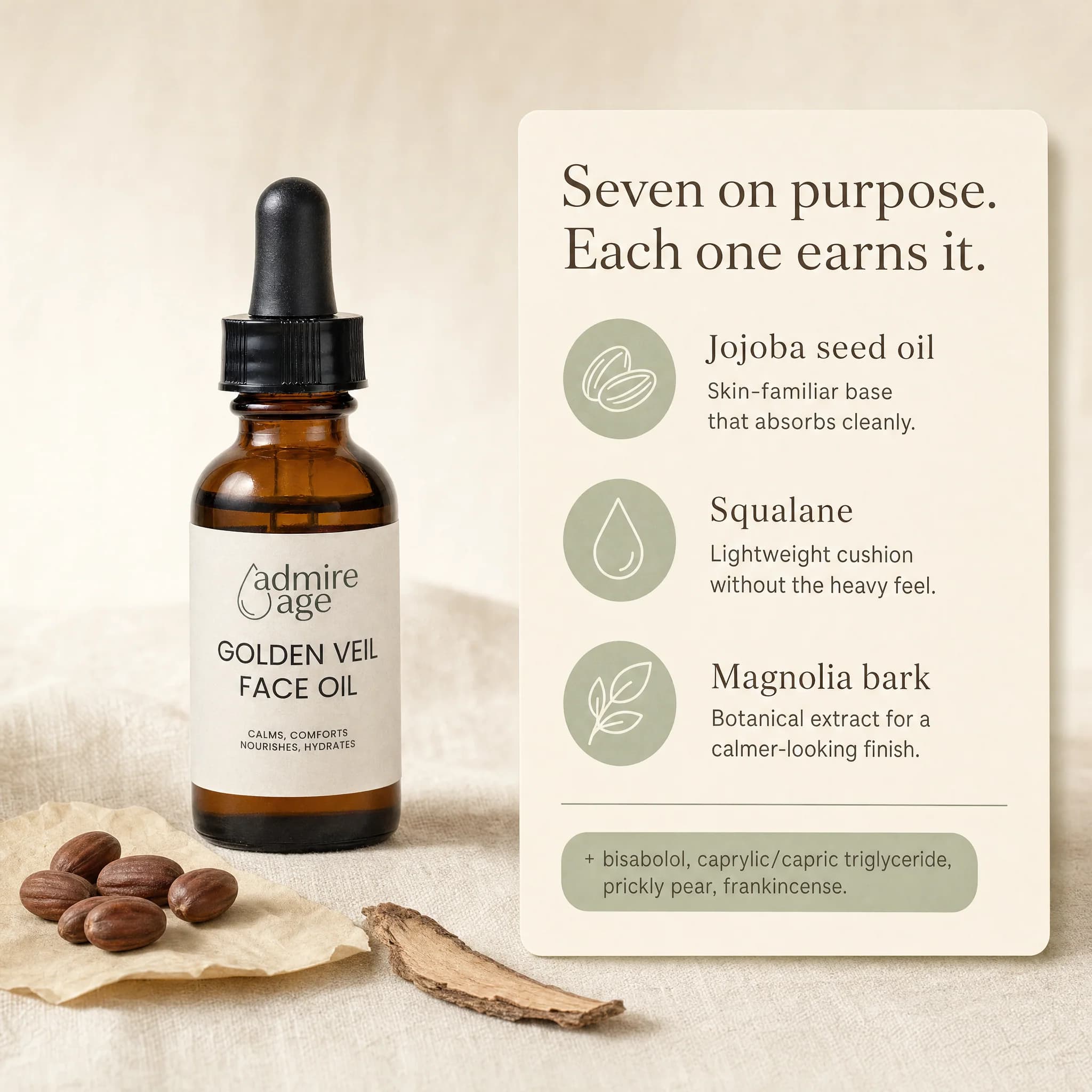 Editorial ingredient still life with a small pile of jojoba seeds on parchment and a thin magnolia bark shard beside the Golden Veil Face Oil bottle on cream linen, with a card to the right titled 'Seven on purpose. Each one earns it.' listing jojoba seed oil, squalane, and magnolia bark with a sage pill noting bisabolol, caprylic/capric triglyceride, prickly pear, and frankincense