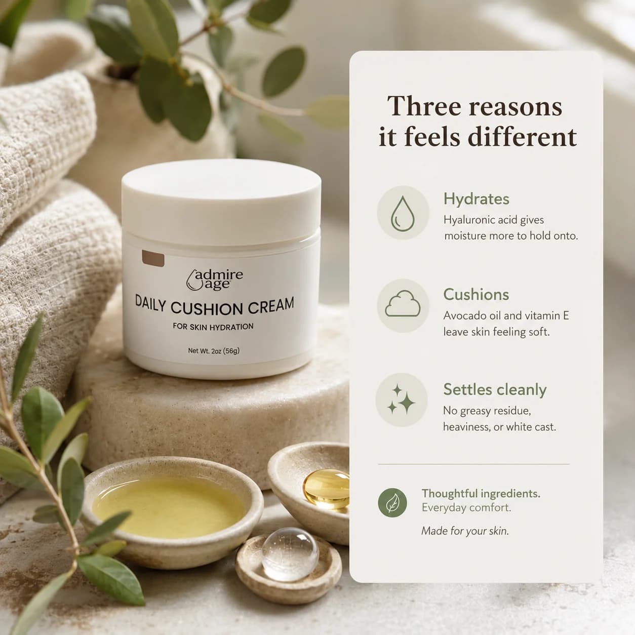 The Daily Cushion Cream jar rests on a stone slab beside small ceramic dishes of avocado oil, a vitamin E capsule, and a clear gel droplet; a card to the right titled 'Three reasons it feels different' lists hydrates, cushions, and settles cleanly