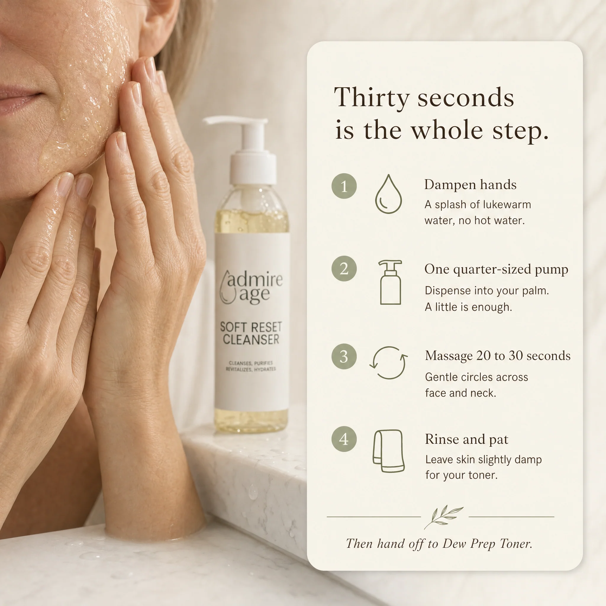 Close-up of a mature woman cleansing at a white marble sink, with the Soft Reset Cleanser bottle in soft focus and a card to the right titled 'Thirty seconds is the whole step.' showing the four-step method: dampen hands, one quarter-sized pump, massage 20 to 30 seconds, rinse and pat